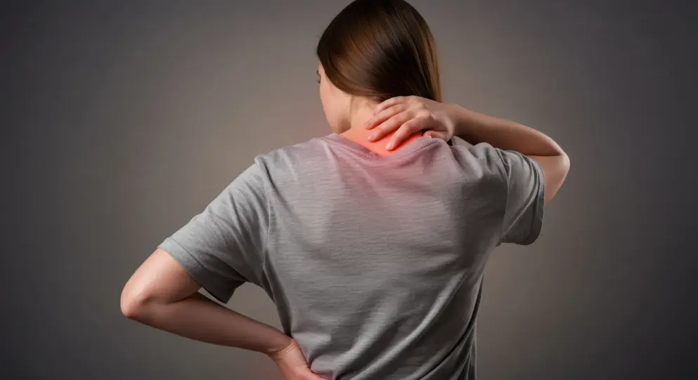 Person holding neck and lower back, indicating musculoskeletal pain or discomfort. 