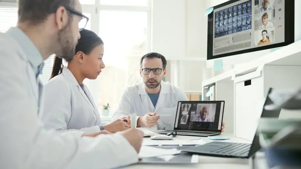 Group of doctors sitting at the table and discussing x-ray images together during a meeting at office