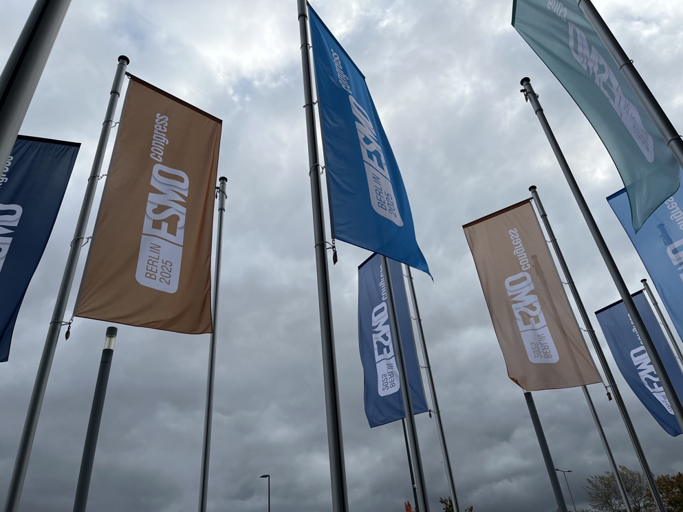 Flags outside the ESMO 2025 Congress venue.